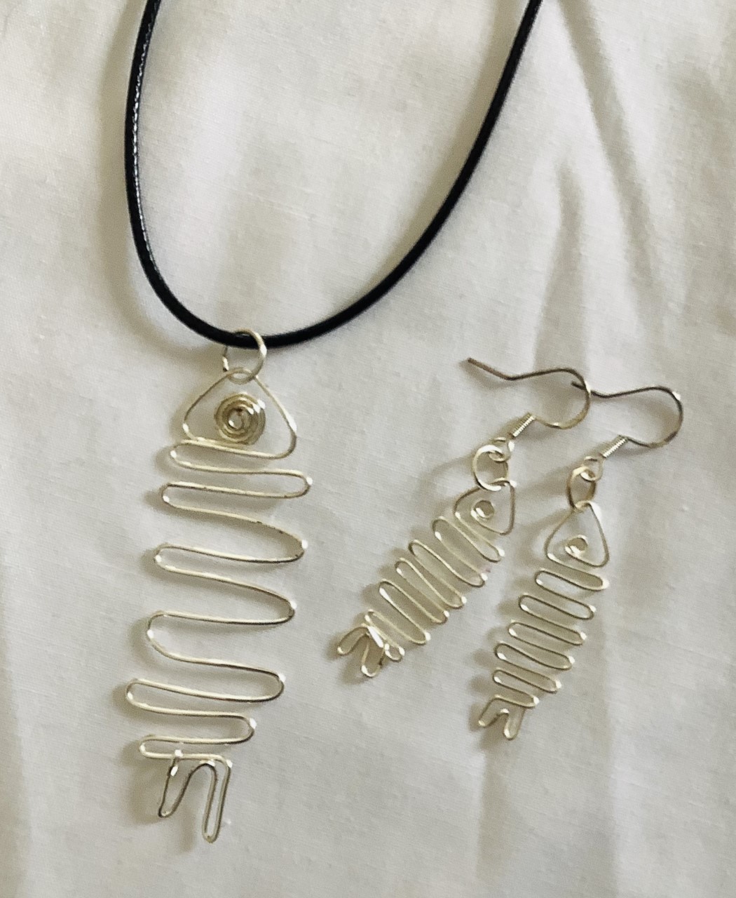FISH Pendants and earrings.  Hand wired individually with in silver coated copper or aluminum wire.  $40.00 a set. Pieces can purchase the pendants and earring separately.