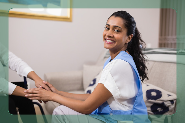 A nurse working and smiling reviewing paperwork with an elderly man