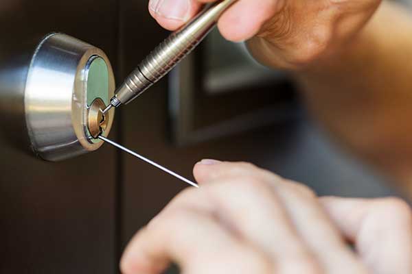 Locksmith Hands Using Pick Tools To Open Locked Door