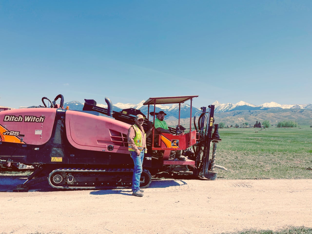 Engineer wearing a hard hat and gloves working on electrical panel in industrial setting.
