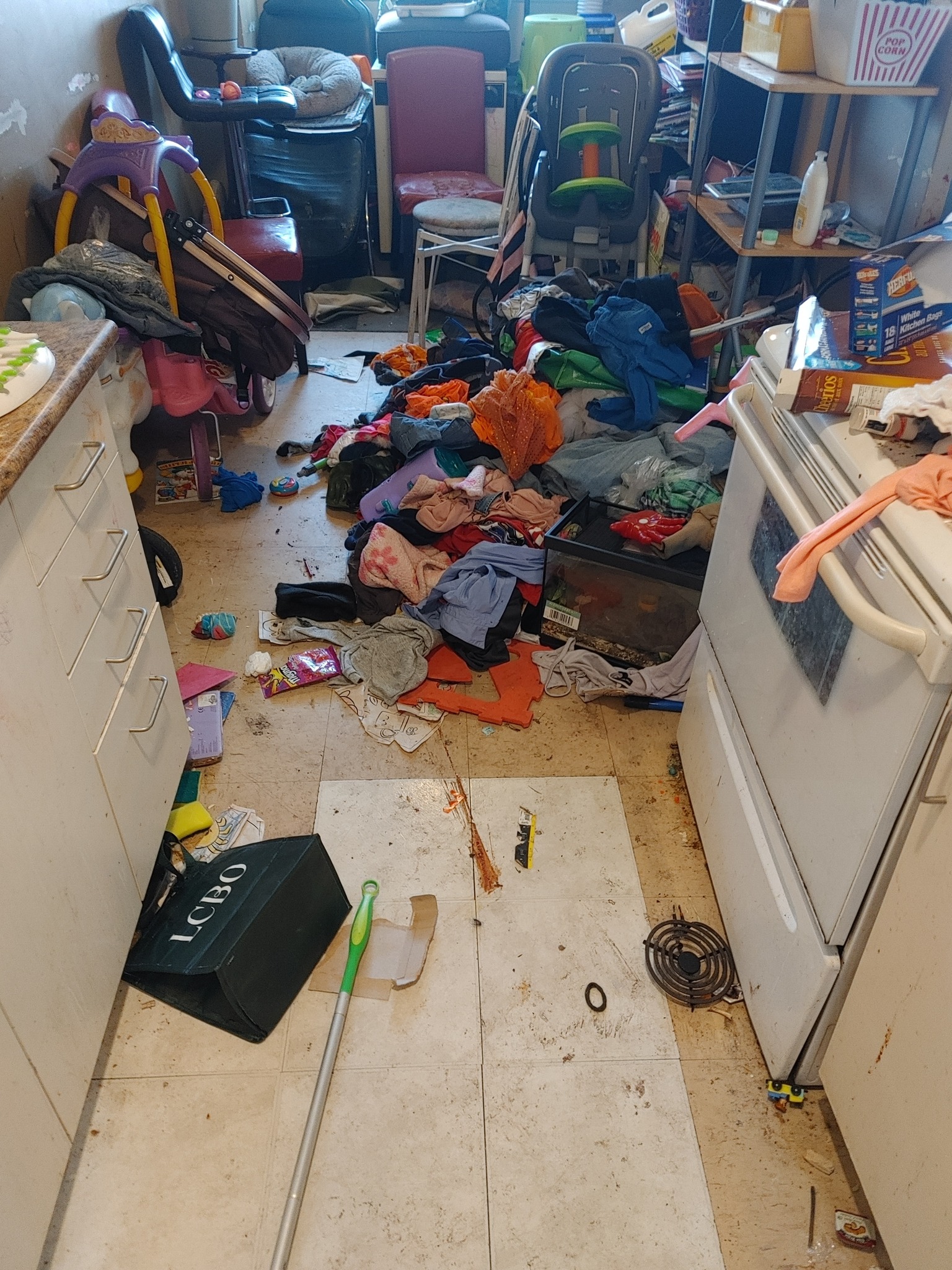 Kitchen in neglected property condition with clutter accumulation, disrupted organization, and reduced functionality requiring structured restoration