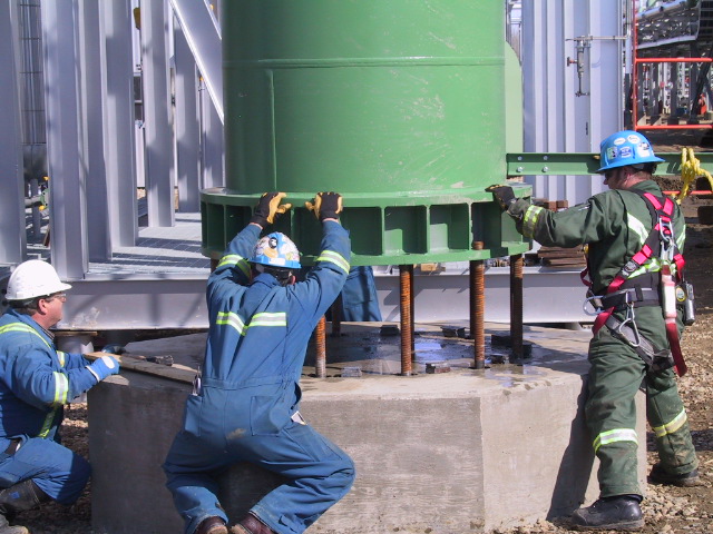 Two engineers wearing safety gear operating machinery at Lazer Energy Services in an industrial setting.